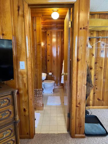 a wooden bathroom with a toilet and a television at Mountain View Lodge in Red River