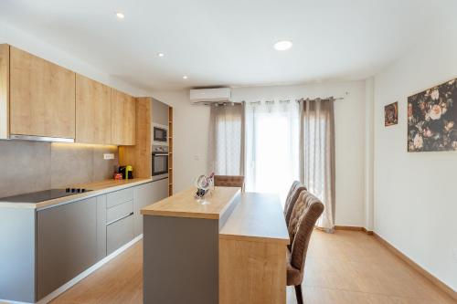 a kitchen with a table and chairs in a room at Magnolija apartmani in Igalo