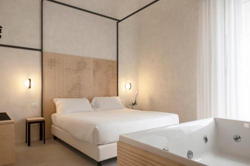 um quarto com uma cama branca e uma banheira em Dome em Catânia