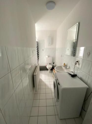 Homefort في دوسلدورف: حمام أبيض مع حوض ومرحاض