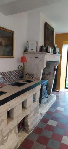 - un salon avec une cheminée en pierre et une table dans l'établissement Maison de Famille, grand jardin et piscine fermée, à Fontenay-le-Comte