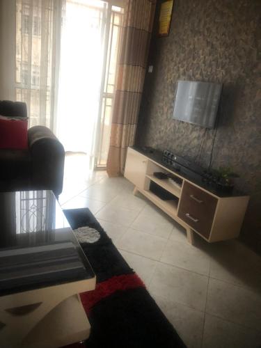 a living room with a couch and a flat screen tv at Brooks apartments in Kampala