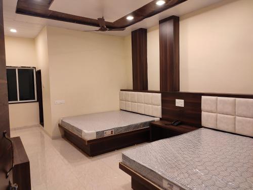 een kamer met 2 bedden en een tv. bij Hotel Vijayshree in Pachmarhī