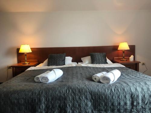 a hotel room with a large bed with towels on it at Willa Anna - Pokoje Gościnne in Goczałkowice-Zdrój