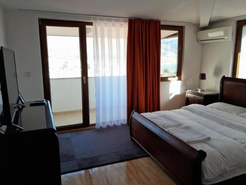 a bedroom with a bed and a large window at Villa Bella in Ohrid