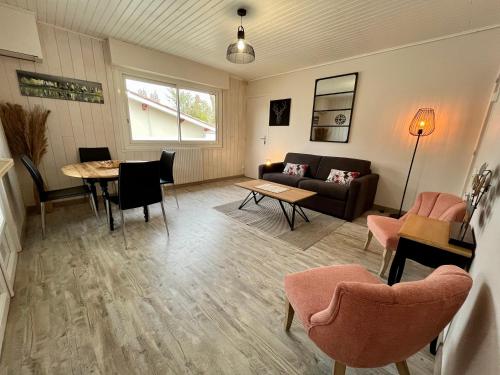 - un salon avec un canapé, une table et des chaises dans l'établissement Villa Petit-Père - à 400m de la plage, à Taussat-les-Bains