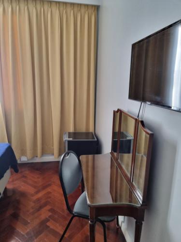 a room with a table and a chair and a television at HOTEL REGIS in Buenos Aires