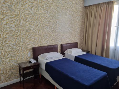 a room with two beds and a wall with a pattern at HOTEL REGIS in Buenos Aires