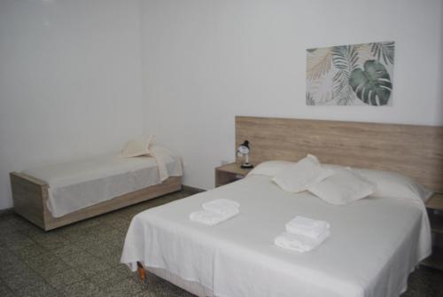 duas camas num quarto de hotel com lençóis brancos em Multiespacio Center em San Fernando del Valle de Catamarca