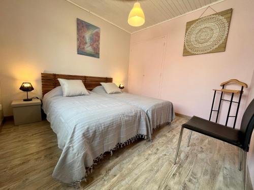 a bedroom with a bed and a chair in it at Villa Petit-Père - à 400m de la plage in Taussat-les-Bains