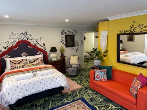 a bedroom with a bed and a mirror and a couch at Highlands Riad in Moss Vale