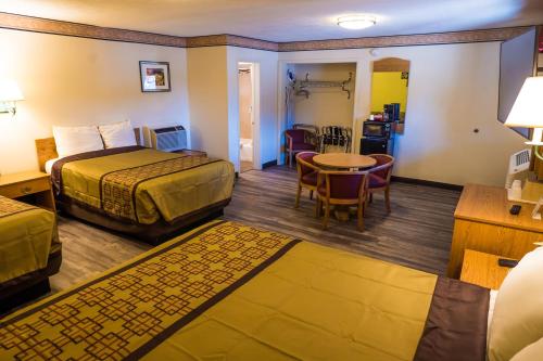 a hotel room with two beds and a table at Rodeway Inn Albuquerque Downtown on Rt 66 in Albuquerque