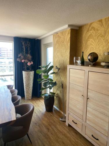 a bedroom with a dresser and a chair and a plant at Scheveningen Diamond View Beach and Harbour in Scheveningen