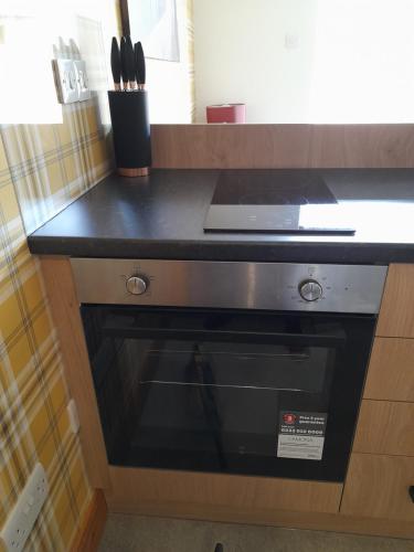 a kitchen counter with a black stove top oven at The Studio in Drumnadrochit