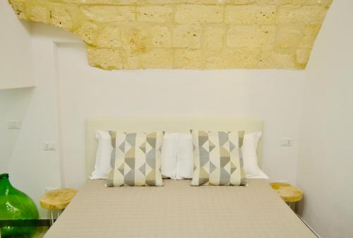 um quarto com uma cama com almofadas em Arvian B&B em Bari