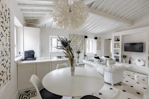 uma sala de jantar branca com uma mesa e cadeiras brancas em Olympia's House em Siena