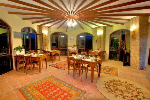 una sala da pranzo con tavoli, sedie e soffitto di Efes Butik Otel a Kirazli