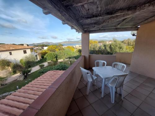 un patio con tavolo e sedie sul balcone. di La Costa Mare a Arzachena