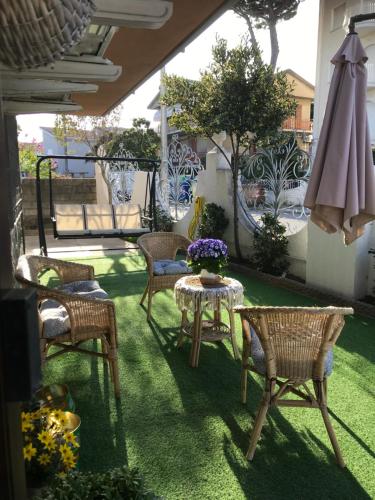 un patio con sillas, una mesa y una sombrilla en B&B La Bohème Porto Garibaldi, en Porto Garibaldi