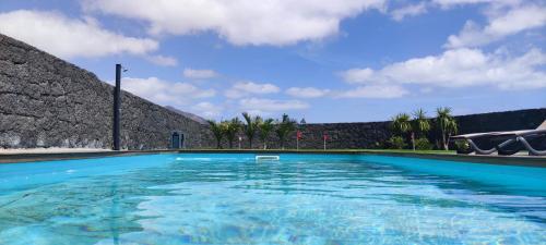 een groot zwembad met blauw water bij Villa Geneva - Relax y diversión in Playa Blanca