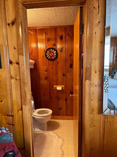 a bathroom with a toilet and a clock on the wall at Mountain View Lodge in Red River