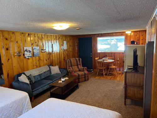 a room with a bed and a couch and a tv at Mountain View Lodge in Red River