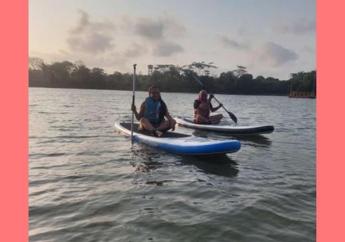 three people are sitting on kayaks in the water at Laguna Rosa Glamping in Coveñas