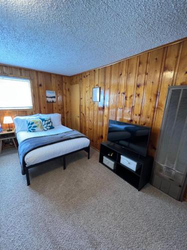 a bedroom with a bed and a flat screen tv at Mountain View Lodge in Red River