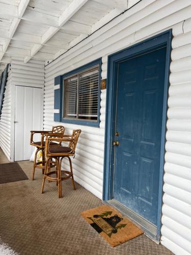a porch with a table and chairs and a blue door at Mountain View Lodge in Red River