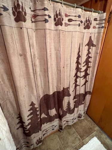 a shower curtain with trees on it in a bathroom at Mountain View Lodge in Red River