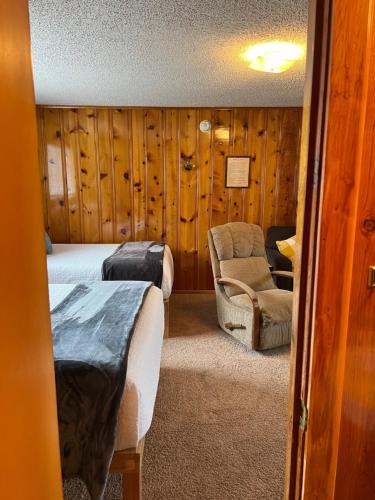 a bedroom with two beds and a chair in a room at Mountain View Lodge in Red River