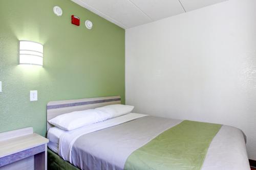a small bedroom with a bed and a green wall at Motel 6-Portland, ME in Portland