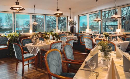 ein Restaurant mit Tischen, Stühlen und Fenstern in der Unterkunft Zur Rennbahn in Drage