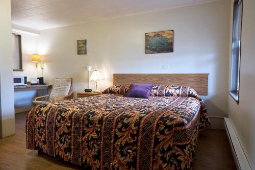una habitación de hotel con una cama y una silla en The King's Inn, en Sidney