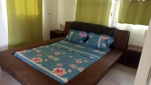 Anse-Bertrand的住宿－Chez Claude，一张带鲜花的蓝色棉被的床