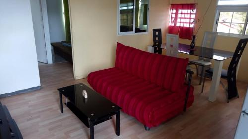 Anse-Bertrand的住宿－Chez Claude，客厅配有红色的沙发和桌子