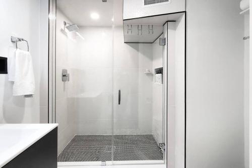 a shower with a glass door in a bathroom at Renovated Guest Suite Near The Lake & High Park in Toronto! in Toronto