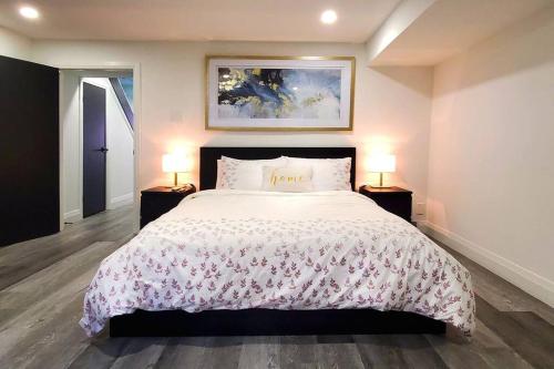 um quarto com uma cama grande e 2 mesas de cabeceira em Renovated Guest Suite Near The Lake & High Park in Toronto! em Toronto