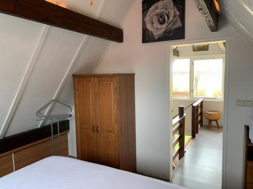 - une chambre avec un lit et un escalier avec une porte dans l'établissement Cosy home near the sea with views and south-facing garden, à Tuitjenhorn
