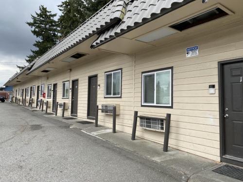 eine Reihe von Häusern mit Fenstern auf einer Straße in der Unterkunft Farwest Motel in Everett