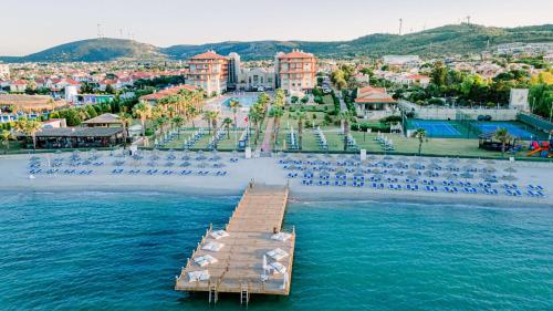 un muelle en el agua junto a una playa con sillas en Radisson Blu Resort & Spa Cesme en Cesme