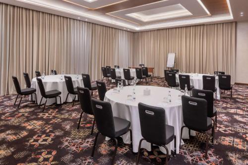 a conference room with white tables and black chairs at Radisson Resort Ras Al Khaimah Marjan Island in Ras al Khaimah