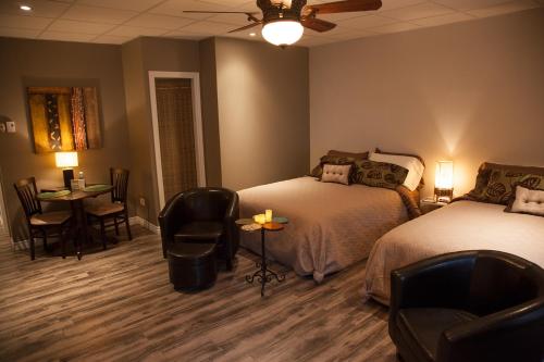 a room with two beds and a table and chairs at Bed and Breakfast Du Repos in Saint Quentin