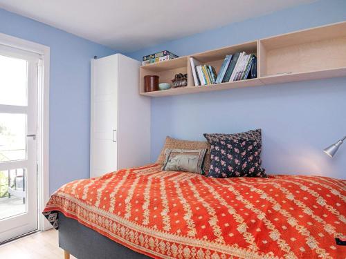 1 dormitorio con 1 cama con pared azul en Holiday home Kerteminde X, en Kerteminde
