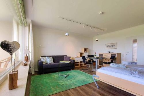 ein Wohnzimmer mit einem Bett und einem Sofa in der Unterkunft Strandhochhaus Döse Ferienwohnung 26 (SH26) in Cuxhaven