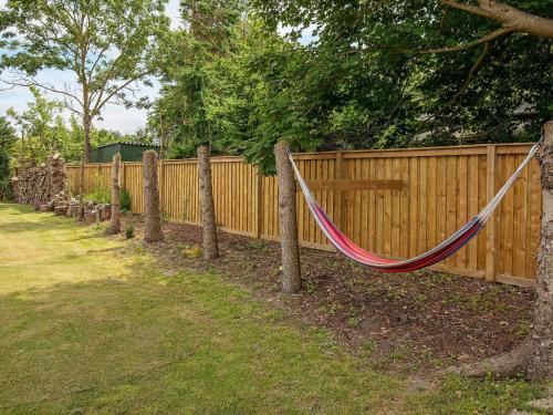 a hammock hanging on a fence in a yard at 5 person holiday home in Væggerløse-By Traum in Marielyst
