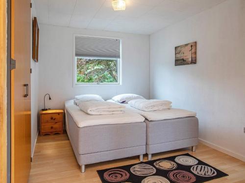 two twin beds in a room with a window at 5 person holiday home in Væggerløse-By Traum in Marielyst