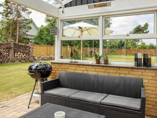a screened in porch with a couch and a grill at 5 person holiday home in Væggerløse-By Traum in Marielyst