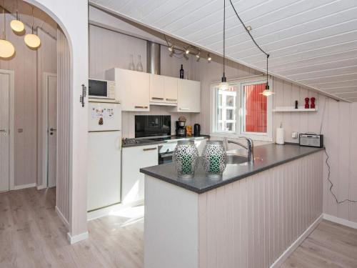 a kitchen with white cabinets and a black counter top at 6 person holiday home in Hemmet in Falen