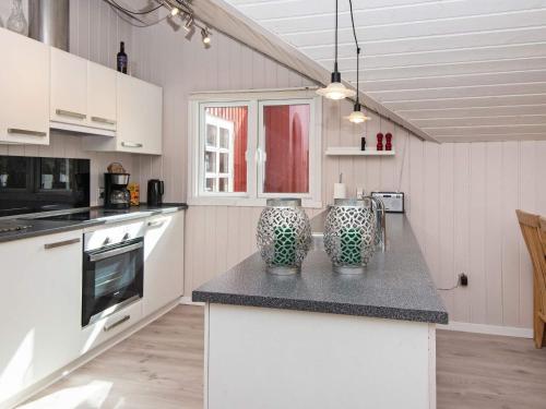 a kitchen with a counter with two vases on it at 6 person holiday home in Hemmet in Falen